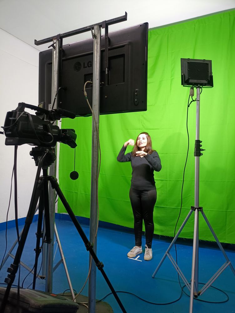 Intérprete de Libras gravando em estúdio com fundo verde de chroma key
